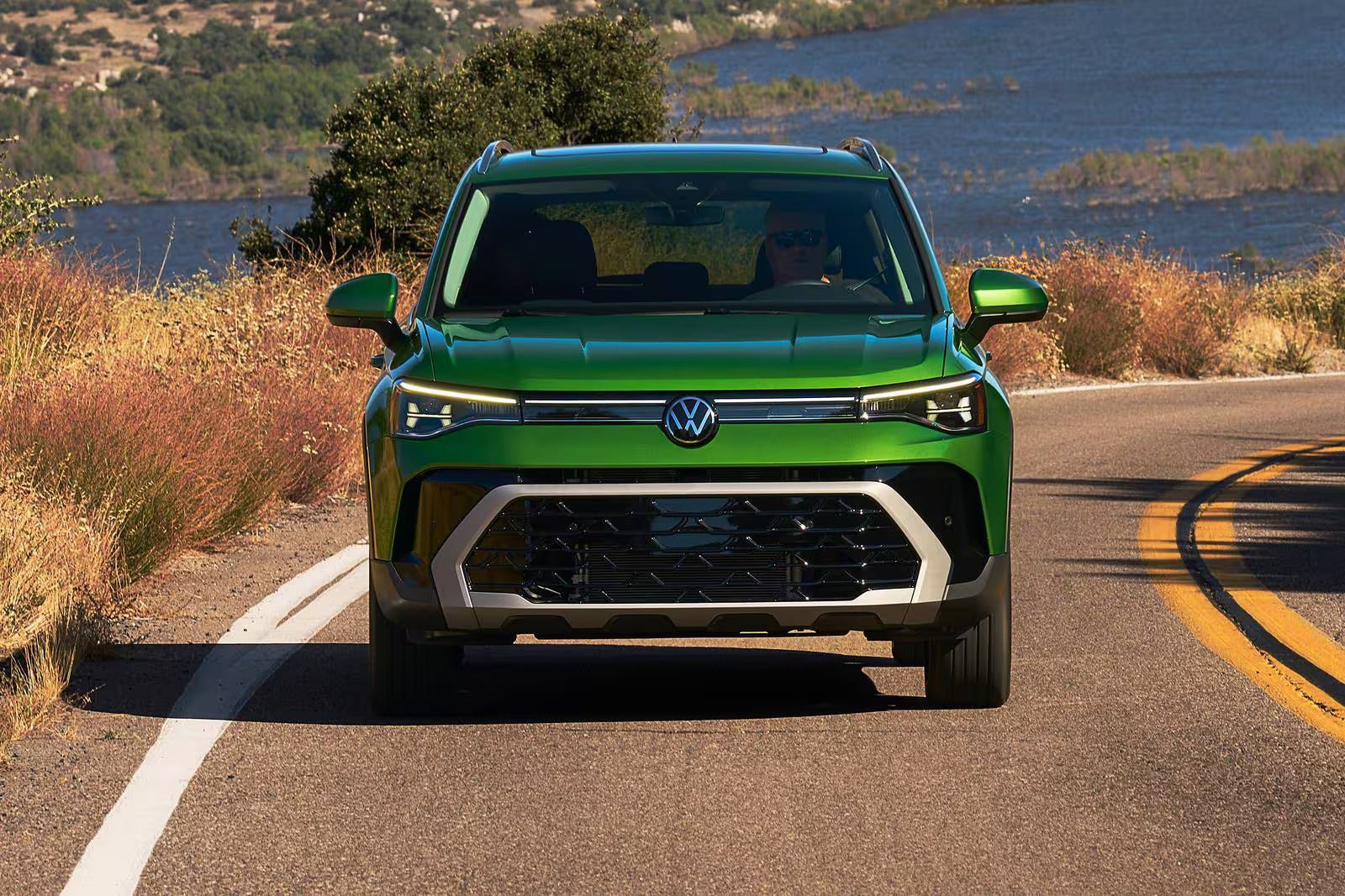A green suv driving on the road.