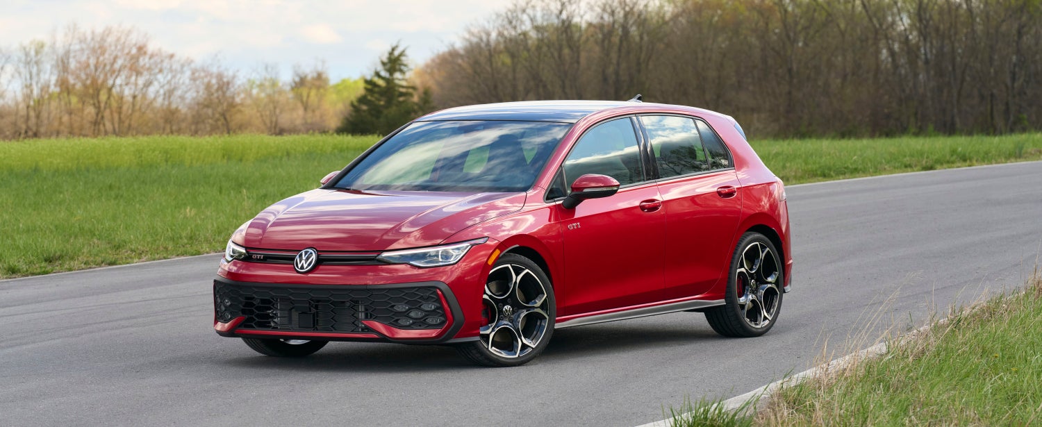2026 Volkswagen Golf GTI parked on a road with nature in the background